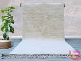 Introducing a plain white handwoven Berber carpet, a versatile addition to any interior. Made from 100% natural wool, this rug boasts a soft, luxurious texture while maintaining resilience for high-traffic areas. The minimalist white design complements any décor, from Scandinavian to eclectic styles. Handcrafted by skilled artisans, this Moroccan-inspired rug features subtle variations in weave, showcasing its authentic handmade character. Ideal for creating a serene, airy ambiance, it works beautifully in