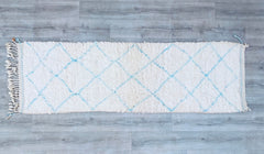 Bring the luxurious texture of Morocco into your home with this handmade Beni Ourain area rug. Woven from premium Atlas Mountain wool, this fluffy, high-pile rug (4x7 ft) offers unmatched softness and durability. The minimalist white and blue geometric motifs reflect traditional Berber craftsmanship, making it a versatile décor piece for any room. Ideal for boho-chic, Scandinavian, or eclectic interiors, this Moroccan wool rug adds warmth and character to living rooms, bedrooms, or nurseries. Each rug is in