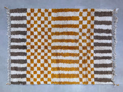 Elevate your décor with this handmade Moroccan Checkered Rug, inspired by the iconic Beni Ourain tribal designs. Featuring a vibrant orange and white checkerboard pattern, this Berber wool rug is soft underfoot and built to last. Each piece is custom-sized, making it ideal for any room—living spaces, nurseries, or entryways. The natural sheep wool ensures warmth and durability, while the tribal geometric motif adds a touch of exotic charm. Free shipping included! A perfect blend of bohemian flair and minima