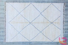 Bring warmth and tradition into your home with this exquisite handmade Moroccan wool rug. Featuring the iconic Beni Ourain design, this authentic Berber carpet showcases a neutral palette with soft ivory and gray tones, perfect for boho, modern, or minimalist interiors. Crafted by skilled artisans using natural wool, this plush shaggy rug adds texture and coziness to any space. Whether placed in the living room, bedroom, or hallway, its tribal patterns and durable craftsmanship make it a timeless floor deco