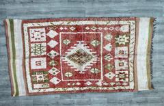 Discover the charm of a tribal Boujad rug, a vintage Moroccan wool carpet featuring bold patterns and rich, faded hues. This handmade Berber rug is crafted using traditional techniques, ensuring durability and a unique distressed look. The intricate geometric motifs and warm color palette make it a perfect fit for eclectic, bohemian, or farmhouse-style spaces. Whether layered over hardwood floors or used as a standalone statement piece, this vintage area rug brings authenticity and global flair to your home