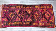 Discover the beauty of this vintage Afghan Baluch rug, a masterpiece of tribal weaving with deep reds, blues, and ivory accents. Made from 100% natural wool, this hand-knotted rug features intricate medallion designs and a plush, high-pile texture. The rich colors and detailed patterns bring a touch of exotic elegance to bedrooms, offices, or entryways. Whether used as a focal point or layered with modern furnishings, this antique rug adds warmth and sophistication. A testament to centuries-old craftsmanshi