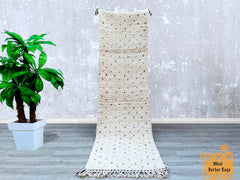 Discover the charm of authentic Beni Ourain runner rugs, handwoven in Morocco’s Atlas Mountains. These vintage-style hallway carpets (2.5x9.3 ft, 3x10 ft, or custom sizes) feature plush wool pile and tribal diamond motifs, ideal for high-traffic areas. The neutral white-and-black palette complements modern, rustic, or Scandinavian décor. As ethically sourced Berber rugs, they support traditional craftsmanship while adding artisanal elegance. Whether for stairs, corridors, or dining rooms, these Moroccan run