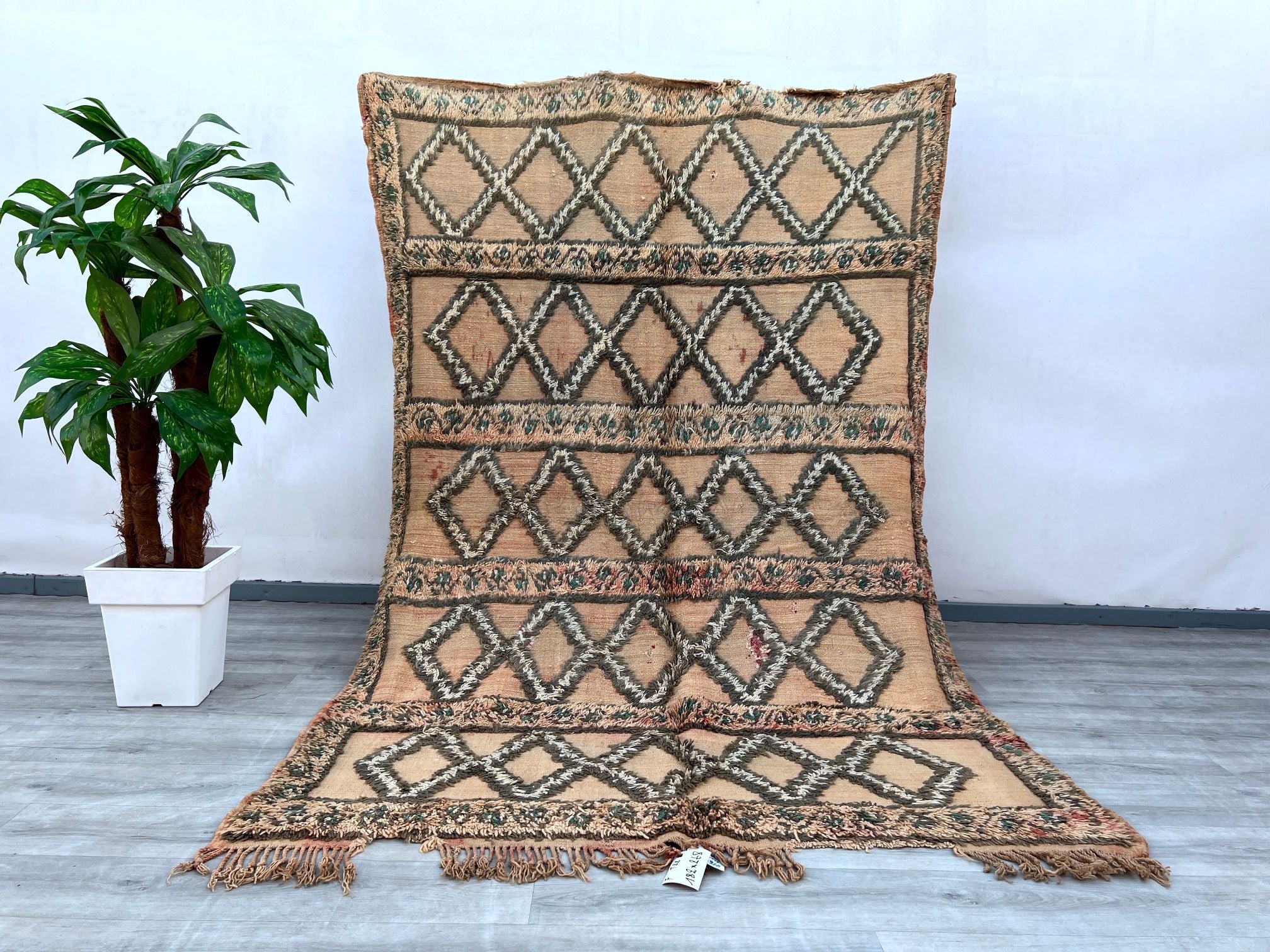 Bring timeless charm to your space with this exquisite vintage Moroccan Berber rug. Handwoven by skilled artisans, this authentic tribal rug features intricate geometric patterns and a rich, natural wool texture. Perfect for adding warmth and character to living rooms, bedrooms, or boho-inspired interiors, this piece showcases traditional craftsmanship with a distressed, vintage appeal. The neutral tones and unique imperfections make it a one-of-a-kind statement piece, blending seamlessly with both modern a