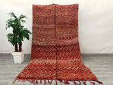 Elevate your home with this vintage 6x10 ft Moroccan rug, a handwoven Berber masterpiece from the Middle Atlas region. Made from natural wool, this Boujaad or Azilal tribal rug boasts a distressed, timeworn look with vibrant reds, creams, and blues. The hand-knotted technique ensures durability, while the organic diamond and zigzag patterns reflect centuries-old craftsmanship. Perfect for bohemian, farmhouse, or modern minimalist spaces, this rug adds texture and history underfoot. Its fair trade origins su