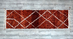 Elevate your home with this authentic Beni Ourain runner rug, handcrafted from premium Moroccan wool for a luxurious yet cozy feel. The neutral ivory and black diamond motifs create a striking boho-chic look, perfect for modern and traditional interiors. At 3x9 feet, this hand-knotted Berber rug is ideal for narrow spaces, adding texture and warmth to hallways, kitchens, or staircases. Each piece is unique, with slight imperfections that highlight its artisanal heritage. The high-pile shag design provides e