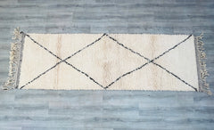 Enhance narrow spaces with handwoven Moroccan runner rugs, featuring the iconic Beni Ourain and Azilal styles. These extra-long carpets (2.7x9.9 ft or 3x10 ft) are perfect for hallways, kitchens, or dining areas, offering slip-resistant durability and a plush, high-pile feel. Made from 100% natural wool, their neutral tones and tribal motifs complement modern farmhouse, Scandinavian, or global boho aesthetics. Each one-of-a-kind rug is hand-knotted by skilled weavers, ensuring heirloom quality. Pair with la