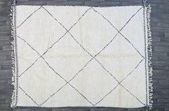 Discover the beauty of handwoven Moroccan textiles with this vintage-inspired Berber rug. Made from premium sheep’s wool, this rug boasts a soft, shaggy texture and tribal geometric patterns that reflect centuries-old weaving traditions. The neutral palette of ivory and charcoal effortlessly blends with modern, rustic, or bohemian interiors, making it a versatile choice for any room. Whether used as a centerpiece in the living room or a plush accent in the bedroom, this artisan-crafted Moroccan carpet bring