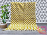 Elevate your space with this vintage Moroccan checkered rug, a stunning hand-knotted wool carpet featuring a bold checkerboard pattern in mustard yellow and cream. This Beni Ourain-style rug is handwoven by Berber women using traditional techniques, ensuring a one-of-a-kind tribal design. The soft, shaggy texture adds depth to boho, eclectic, or mid-century modern interiors, while the neutral color palette blends seamlessly with any decor. Perfect for living rooms, nurseries, or dining areas, this Moroccan