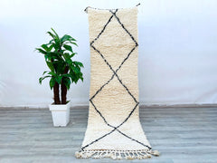 Bring a touch of Morocco into your home with this handmade Beni Ourain runner rug, crafted from 100% natural wool. The 3x8 ft size fits perfectly in hallways, staircases, or as a stylish kitchen runner. Featuring a minimalist white and black tribal pattern, this rug adds texture and elegance to any room. The high-pile wool provides a soft, cozy feel underfoot, while the durable weave ensures long-lasting beauty. Each piece is one-of-a-kind, showcasing traditional Berber weaving techniques. Whether layered o