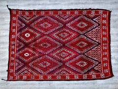 This vintage Turkish Kilim rug is a masterpiece of Anatolian weaving, featuring a striking geometric design in warm, earthy tones. Unlike pile rugs, Kilims are flat-woven, making them lightweight and versatile—perfect as a wall hanging, table runner, or floor accent. The intricate embroidery and tribal patterns reflect traditional craftsmanship, while the distressed vintage look adds rustic charm. Whether layered over hardwood floors or draped as a decorative textile, this handwoven Kilim brings a touch of