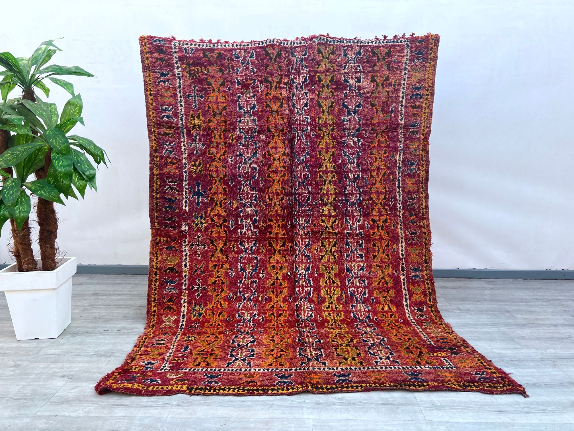 Enhance your décor with this stunning antique wool rug, featuring bold tribal motifs and a luxurious handmade feel. Woven using age-old techniques, this piece boasts a soft, high-pile texture and a captivating mix of natural dyes, creating a harmonious blend of colors. The intricate patterns, inspired by traditional nomadic designs, add depth and movement to any room. Whether placed in a modern loft, a cozy bungalow, or a global-inspired retreat, this rug effortlessly infuses warmth and sophistication. Its 