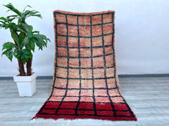 Handcrafted by skilled artisans, this vintage Azilal Berber rug showcases the vibrant colors and abstract motifs characteristic of Moroccan tribal design. Measuring approximately 4.1x7.9 feet, this rug is made from soft, high-quality wool, offering both durability and a luxurious texture. The playful, asymmetrical patterns and faded hues give it a charmingly rustic appeal, ideal for boho-chic or minimalist decors. Each knot is tied by hand, ensuring a one-of-a-kind piece with slight variations that highligh
