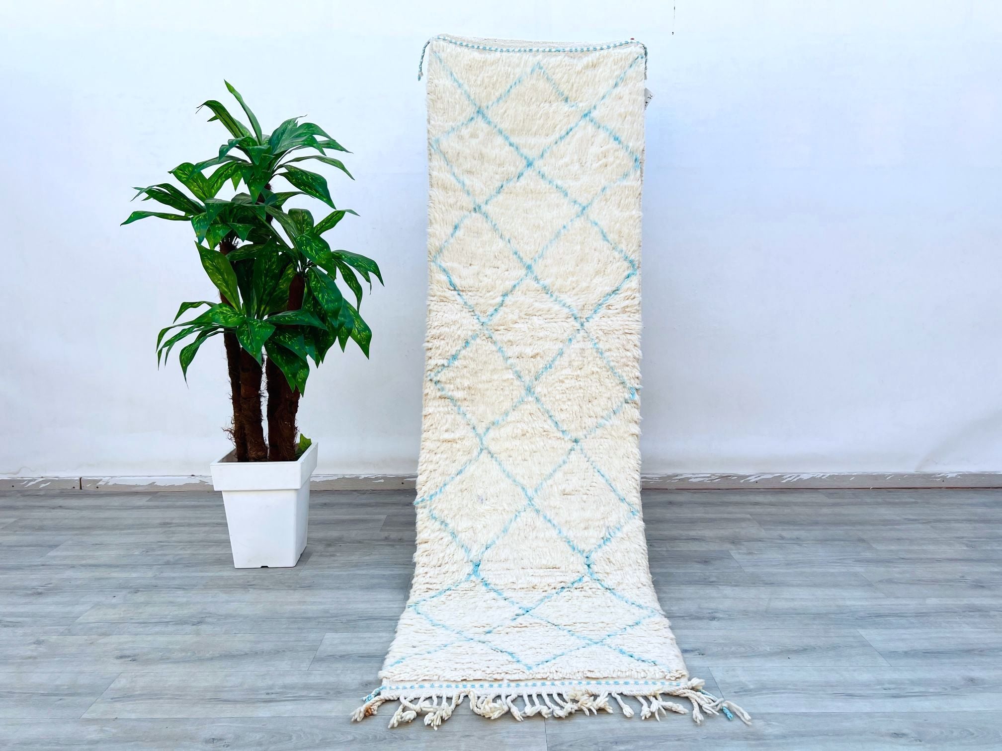 Elevate your home with this authentic Beni Ourain Moroccan rug, a hand-knotted wool masterpiece featuring a classic black and white tribal pattern. Measuring 3x10 ft, this long hallway runner is perfect for adding texture and warmth to any room. Made by Berber weavers using centuries-old techniques, each rug is one-of-a-kind with slight variations that enhance its charm. The plush, high-pile wool ensures softness underfoot, while the neutral tones complement both modern and rustic décor. Whether used as a l