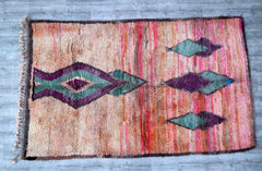This hand-knotted Moroccan Berber rug is a masterpiece of craftsmanship, featuring intricate geometric motifs and a luxuriously soft wool pile. The vibrant colors and unique patterns reflect the rich cultural heritage of Moroccan weaving traditions. Perfect for layering in living rooms, bedrooms, or dining areas, this rug adds texture and depth to any decor style—from bohemian to minimalist. Its vintage-worn look enhances its charm, making each piece one-of-a-kind. A must-have for those who appreciate artis