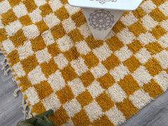 Bring rustic charm into your home with an authentic Moroccan checkered rug, handwoven by Berber artisans. Available in soft beige, bold orange, or radiant yellow, these wool rugs feature a timeless checkerboard motif that complements both modern and traditional décor. The thick, plush texture provides comfort, while the durable handmade construction ensures longevity. Whether you need a large area rug, a hallway runner, or a cozy accent piece, these Beni Ourain and Boujaad-style rugs offer versatility and e