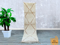 Bring rustic charm to your home with this custom-sized Moroccan Berber runner rug, handwoven by indigenous artisans. The 2.5x9.4 FT dimensions make it perfect for narrow hallways, kitchens, or loft spaces. Made from premium sheep’s wool, this rug boasts a luxuriously thick pile and organic variations in its cream-and-chocolate trellis design. The hand-knotted technique ensures longevity, while the undyed wool offers an eco-friendly touch. A versatile statement piece, it pairs well with minimalist, eclectic,
