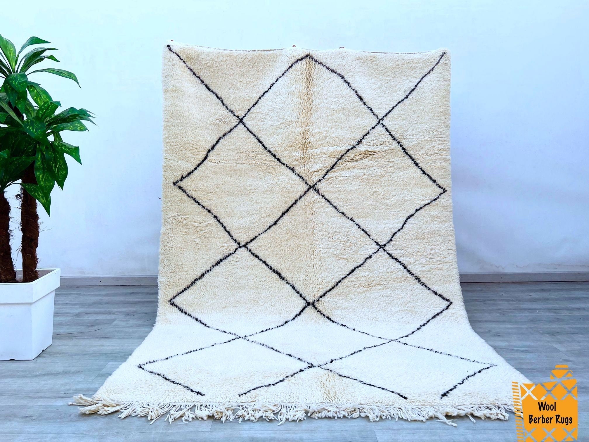 Elevate your interior with this bohemian Moroccan wool rug, a stunning handwoven Berber carpet that blends artistry and functionality. Featuring intricate tribal patterns in neutral tones, this vintage-inspired rug adds character and warmth to any room. The high-quality wool ensures a soft, luxurious feel, while the durable hand-knotted construction promises long-lasting beauty. Perfect for boho, eclectic, or mid-century modern spaces, this authentic tribal rug makes a striking statement in living areas, be