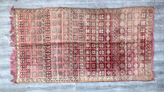 Infuse your home with bohemian elegance using this vintage Moroccan carpet, handcrafted by skilled weavers. The tribal-inspired patterns and deep red, gray, and maroon hues create a captivating focal point in any room. Woven from high-quality wool, this handmade Berber rug is both soft and resilient, ideal for cozy living spaces. Its distressed vintage look adds character, making it perfect for eclectic, mid-century, or farmhouse-style interiors. Whether layered over hardwood floors or used as a standalone 