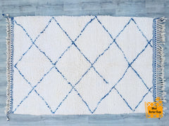 Elevate your décor with this hand-knotted Moroccan rug, showcasing a beautiful blend of blue and white in a distinctive geometric design. Woven by Berber women artisans, this luxurious wool rug is soft, durable, and naturally insulating, perfect for cozy interiors. The Beni Ourain-inspired pattern adds an ethnic yet modern touch, fitting seamlessly into Scandinavian, eclectic, or mid-century styles. Whether placed in a living room, nursery, or office, this handmade carpet brings artistic flair and cultural 