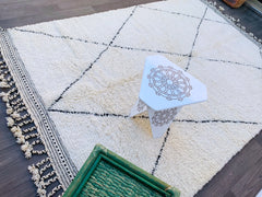 Looking for a custom-sized Moroccan Berber rug? This Beni Ourain wool carpet is hand-knotted by skilled artisans, offering plush comfort and durability. Its black-and-white diamond motifs bring boho-chic elegance to any room—perfect for modern, farmhouse, or global-inspired decor. Choose from various dimensions (up to 323x198 cm) and enjoy fast shipping in India, Europe, and the US. A sustainable, fair-trade choice for those who love authentic ethnic textiles. 70% OFF deals available on Etsy and other trust