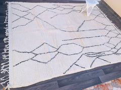 Enhance your space with a bespoke Beni Ourain Moroccan rug, meticulously handwoven by Berber women using premium undyed wool. This soft, hypoallergenic rug showcases black tribal motifs on a cream background, making it a versatile floor covering for modern and rustic interiors alike. Whether you prefer a small accent rug or a large statement piece, this eco-friendly Moroccan carpet is durable, stain-resistant, and easy to maintain. Shop now on Etsy, MoroccanWoven, or Kasbah Art Tresor for exclusive designs 