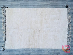Discover the beauty of a custom wool Beni Ourain area rug, meticulously crafted for understated elegance. This handmade Moroccan rug features a solid white design with a plush, high-pile finish, offering unmatched comfort underfoot. Woven using traditional Berber techniques, each piece showcases slight imperfections, highlighting its artisanal authenticity. The breathable wool material ensures year-round comfort, while the neutral white hue effortlessly brightens any room. Perfect for layering or as a focal