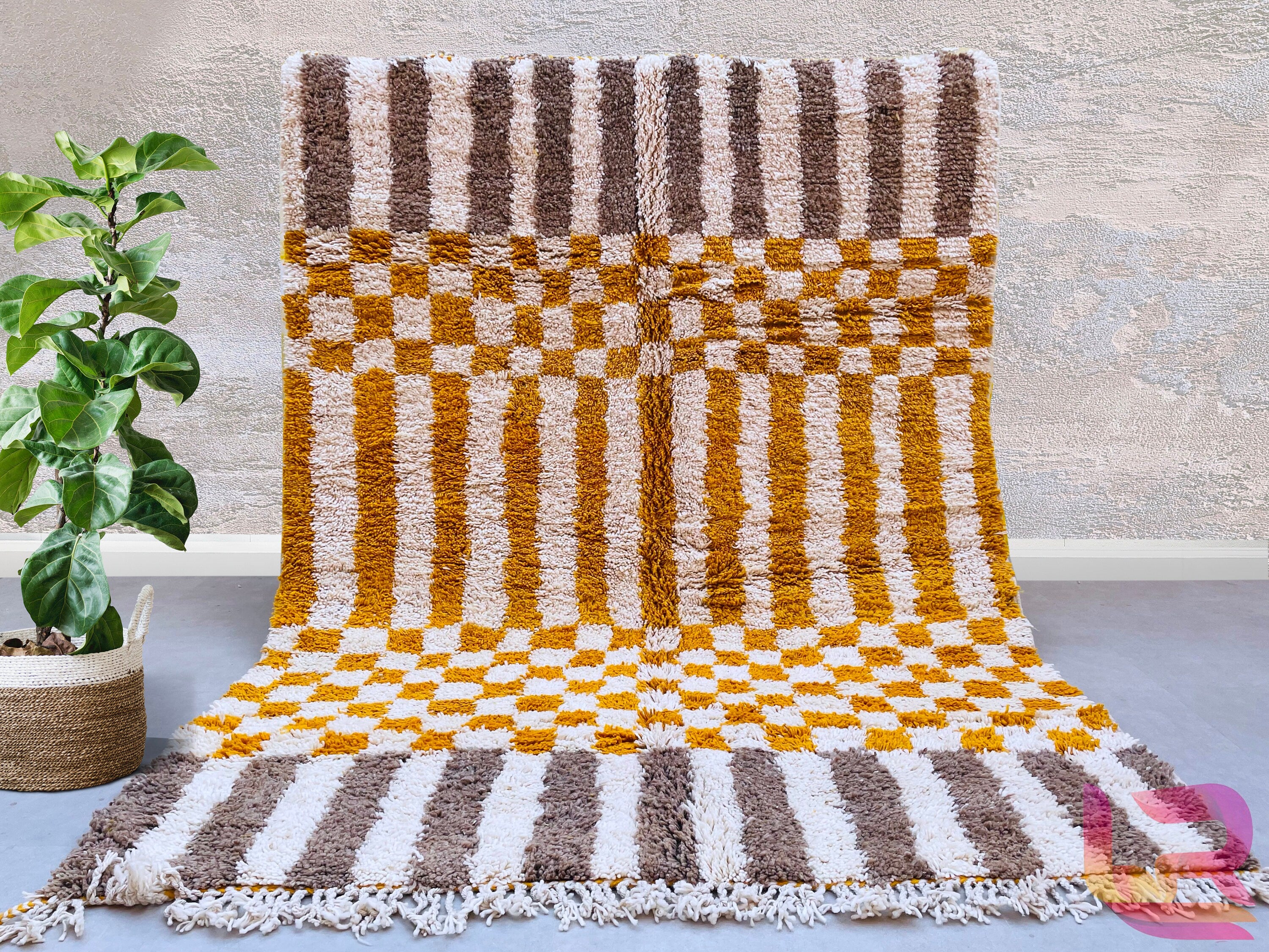 Bring timeless elegance to your home with this handmade Moroccan Orange Checkered Area Rug, a stunning Beni Ourain Berber carpet crafted with premium sheep wool. Featuring a bold checkered pattern in warm orange and white tones, this rug adds a bohemian yet sophisticated touch to any living space. Perfect for modern, boho, or eclectic interiors, it’s soft, durable, and custom-sized to fit your needs. Each rug is authentically handwoven by Berber artisans, ensuring unique craftsmanship. Free shipping makes i
