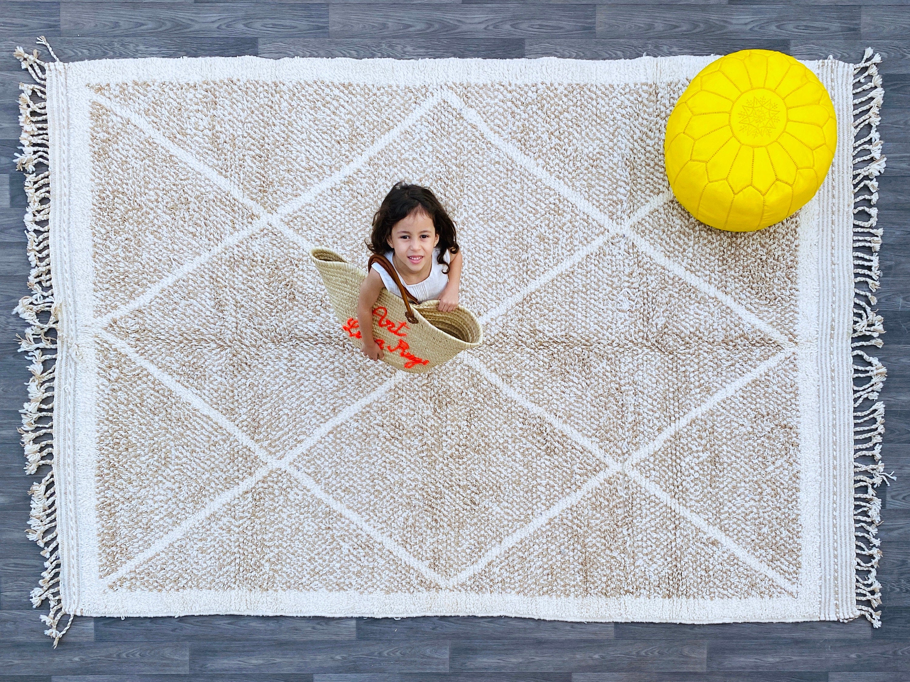 Bring timeless elegance to your space with this hand-knotted Moroccan Berber rug, crafted by skilled artisans using 100% natural wool. Measuring 7x10ft, this Azilal-style rug features intricate tribal patterns and a soft, plush texture, perfect for living rooms, bedrooms, or boho-chic interiors. Each rug is unique, showcasing traditional Berber designs with neutral tones that blend seamlessly into modern and rustic décor. The Beni Ourain-inspired geometric motifs add warmth and character, while the durable 