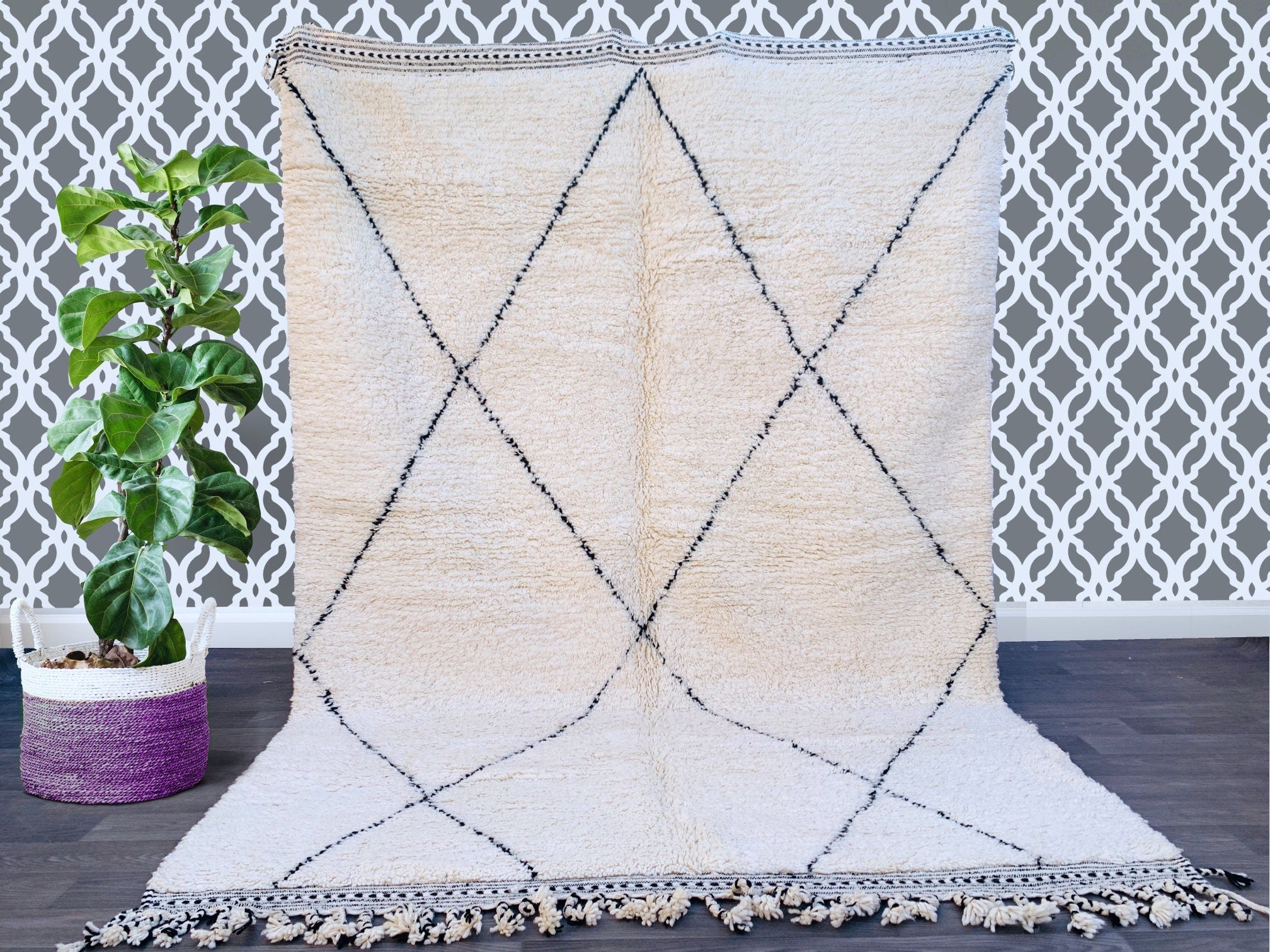 Discover the timeless beauty of a handmade Moroccan Beni Ourain rug, crafted by Berber artisans using 100% pure wool. This authentic vintage rug features a soft, plush texture and a minimalist black-and-white diamond pattern, perfect for boho, modern, or rustic interiors. Available in custom sizes, this luxurious Berber carpet adds warmth and elegance to any space—ideal for living rooms, bedrooms, or home decor. Shop bohemian rugs online with free shipping options. A sustainable, ethically sourced piece tha