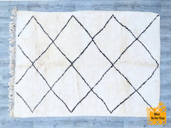 Bring timeless elegance to your home with this handmade Moroccan Beni Ourain rug, crafted by skilled Berber artisans. Woven from natural wool, this authentic piece features a minimalist black-and-white geometric design, perfect for adding warmth and texture to any space. The soft, plush pile ensures comfort underfoot, making it ideal for living rooms, bedrooms, or cozy reading nooks. Each rug is unique, showcasing traditional craftsmanship with subtle variations that highlight its handmade charm. Whether yo