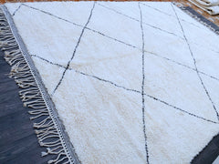 Bring timeless elegance into your home with this handmade Moroccan Beni Ourain rug, crafted by skilled Berber artisans using 100% natural wool. Known for its plush texture and neutral tones, this authentic Berber carpet features traditional tribal patterns, adding a bohemian and rustic charm to any space. Perfect for living rooms, bedrooms, or cozy reading nooks, this handwoven Moroccan rug is durable, soft, and ethically made. Each piece tells a story through its unique geometric designs, making it a state
