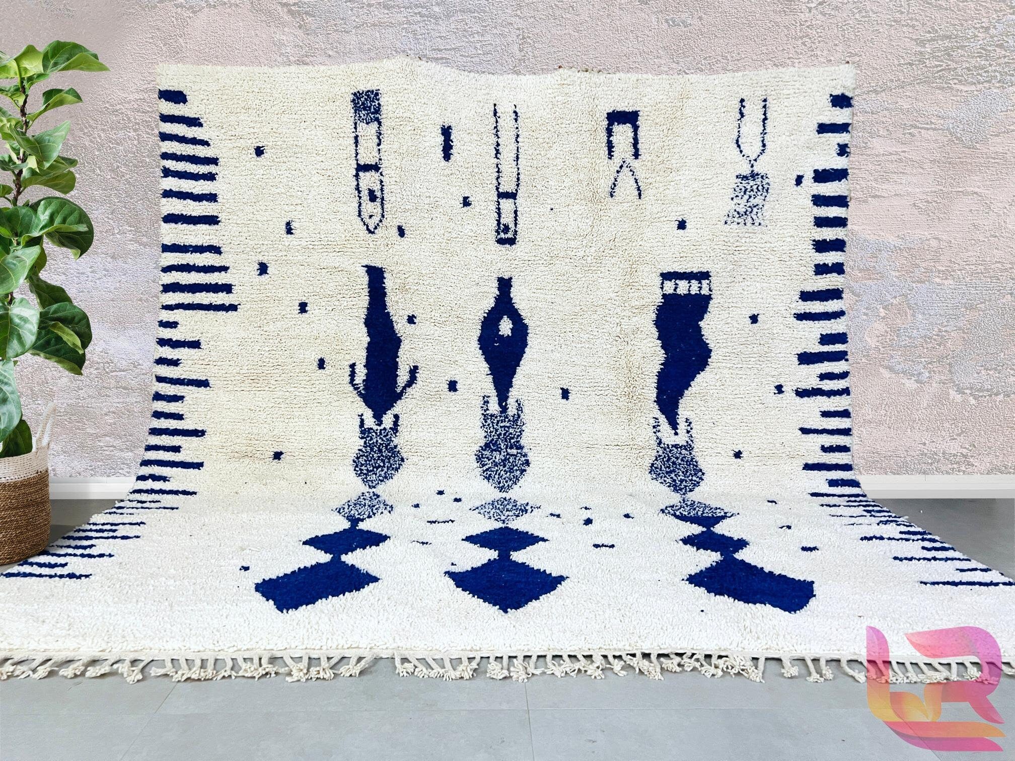 Bring timeless elegance into your home with this handmade Moroccan Blue Beni Ourain rug, a stunning piece of authentic Berber craftsmanship. Woven by skilled artisans using premium wool, this rug features a soft ivory and deep blue geometric design, perfect for adding a bohemian touch to any space. The natural wool fibers provide durability and a plush feel underfoot, making it ideal for living rooms, bedrooms, or cozy reading nooks. Each rug is hand-knotted, ensuring a unique, one-of-a-kind piece that refl