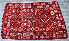 A stunning 6x10 ft handmade Moroccan rug, this piece is woven with premium wool using traditional Berber techniques. The Boujaad and Azilal influences are evident in its bold patterns and earthy tones, perfect for adding character to any room. Each rug is uniquely knotted, ensuring no two are alike. The durable construction withstands daily use while maintaining its beauty. Whether displayed in a cozy reading nook or as a focal point in a dining area, this rug exudes rustic elegance. Embrace the charm of Mo