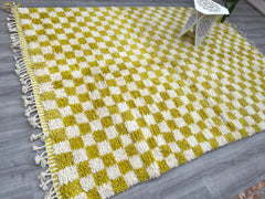 Add a pop of artisanal charm to your home with this handwoven Moroccan Azilal rug, featuring a vibrant checkered pattern in yellow, white, and earthy tones. Made from premium sheep wool, this Bohemian-style rug is hand-knotted by skilled Berber weavers, ensuring a unique, textured finish. The tribal geometric design brings a global boho vibe to living rooms, bedrooms, or entryways, while the plush high pile offers unmatched comfort. Ideal for eclectic, farmhouse, or modern interiors, this checkered Moroccan