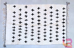 Elevate your living space with a handwoven Moroccan Beni Ourain rug, featuring striking black and white geometric patterns. These authentic Berber rugs are crafted from natural wool, offering a plush, shaggy texture perfect for Scandinavian, bohemian, or modern interiors. The monochrome design blends effortlessly with neutral decor, adding warmth and cultural charm to any room. Whether used as a living room centerpiece, hallway runner, or bedroom accent, this handmade Moroccan carpet brings elegance and art