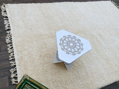 Bring Moroccan charm into your home with this handmade Beni Ouarain Berber rug, a soft, shaggy wool carpet in a classic cream-white hue. Measuring 258 x 163 cm, this authentic tribal rug is woven by Berber women using natural, undyed wool, creating a plush, high-pile texture that feels heavenly underfoot. The subtle ivory tones and minimalist design make it a perfect fit for Scandinavian, modern farmhouse, or boho-chic décor. Ideal for living rooms, nurseries, or cozy reading nooks, this Moroccan wool rug a