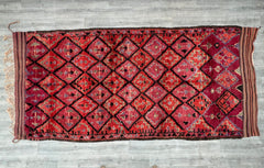 Bring rustic elegance into your home with this vintage Berber rug, a 6x13 ft handwoven Moroccan carpet featuring authentic tribal motifs. Made from natural, undyed wool, this Beni Ourain-style rug offers a plush, cozy feel underfoot, ideal for high-traffic areas. The geometric designs and neutral hues make it versatile for modern, farmhouse, or eclectic interiors. Each piece is hand-knotted by Moroccan artisans, ensuring durability and a unique, artisanal touch. Whether used as a statement floor piece or a 