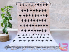 Enhance your home with a minimalist Moroccan Berber rug, showcasing subtle off-white tones and bold black tribal motifs. These handmade wool rugs feature soft, plush pile and timeless designs, making them ideal for Scandinavian, farmhouse, or contemporary decor. The neutral color palette effortlessly complements any interior style, while the authentic Berber patterns add a touch of global elegance. Perfect as a living room focal point, bedroom accent, or cozy nursery rug, this artisan-crafted piece combines
