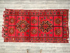 Bring timeless elegance to your home with this vintage Moroccan rug, a handmade 6x12 Berber carpet featuring Boujad tribal motifs in soft, natural wool. This authentic vintage rug showcases a distressed, old-world charm, with subtle variations in weave and dye that highlight its artisanal craftsmanship. The large 5.9 ft x 12.2 ft size makes it perfect for anchoring living rooms, bedrooms, or open-concept spaces, while its durable wool construction ensures years of use. The tribal geometric patterns add dept