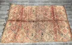 Discover the artistry of Moroccan weaving with this authentic vintage Boujaad rug, a 6x11-foot handwoven treasure from the heart of Berber culture. Adorned with tribal patterns in muted tones of rust, cream, and indigo, this rug exudes rustic elegance and timeless appeal. Crafted from natural, undyed wool, it boasts a sturdy yet plush feel, suitable for both floor decor and wall hangings. The Boujaad tribal design is revered for its raw, organic aesthetic, making each piece uniquely imperfect. Ideal for boh