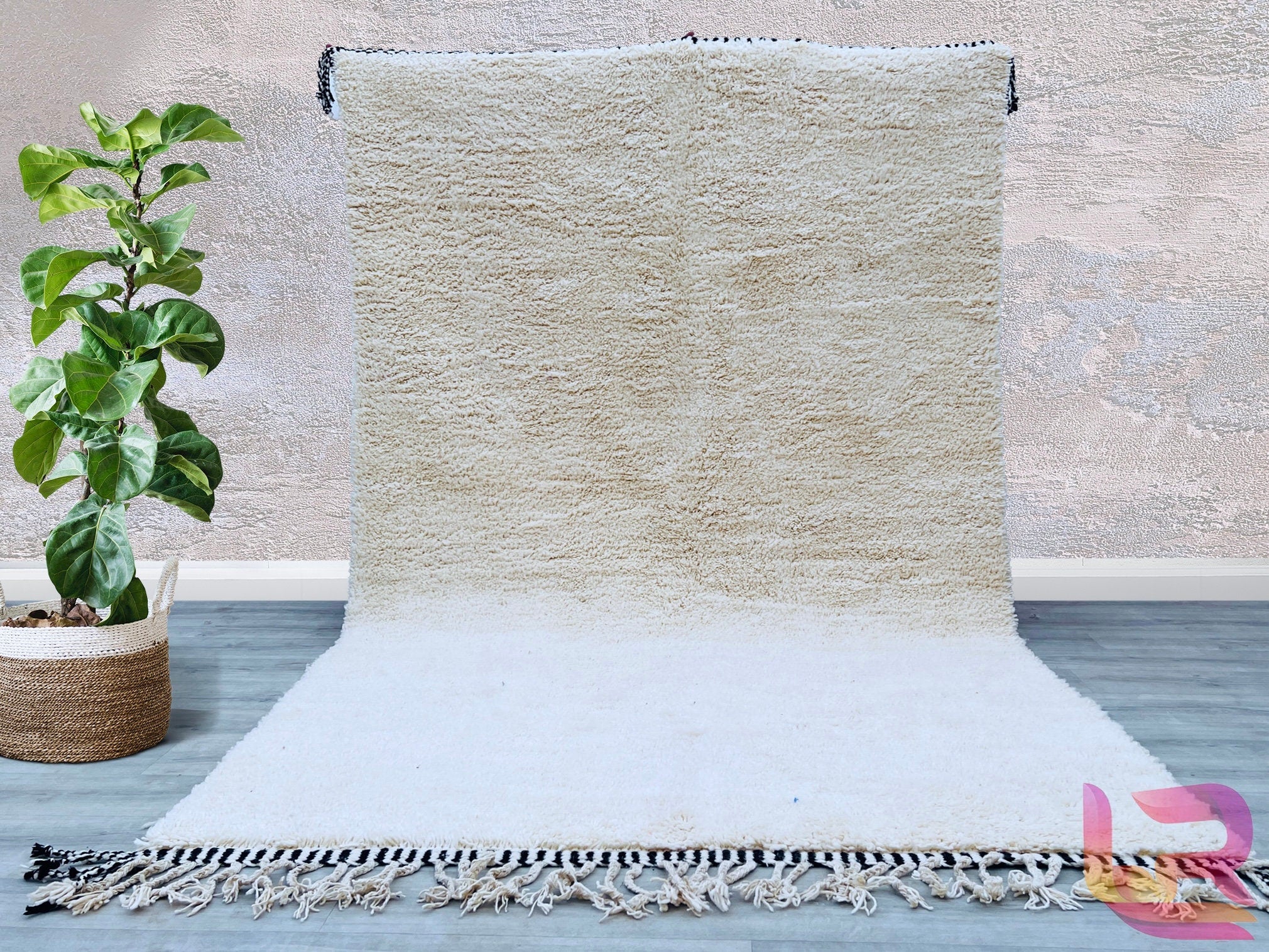 Introducing a plain white handwoven Berber carpet, a versatile addition to any interior. Made from 100% natural wool, this rug boasts a soft, luxurious texture while maintaining resilience for high-traffic areas. The minimalist white design complements any décor, from Scandinavian to eclectic styles. Handcrafted by skilled artisans, this Moroccan-inspired rug features subtle variations in weave, showcasing its authentic handmade character. Ideal for creating a serene, airy ambiance, it works beautifully in 