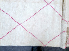 Enhance your space with this beautifully crafted pink Moroccan wool rug, blending boho flair with traditional craftsmanship. Made from 100% natural wool, this Berber rug offers a soft, durable surface with a subtle pink hue, perfect for adding a pop of color to neutral interiors. The intricate tribal patterns reflect authentic Moroccan artistry, making each piece one-of-a-kind. Ideal for layering in living rooms, nurseries, or yoga spaces, this rug combines comfort and style effortlessly. Handmade with care
