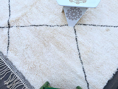 Experience the comfort and beauty of this thick wool Moroccan rug, inspired by traditional Beni Ourain designs. Handwoven by skilled artisans, it boasts a plush, high-pile texture that feels incredibly soft underfoot. The neutral black and white patterns effortlessly complement various interior styles, from bohemian to minimalist. Perfect for adding warmth and character to any room, this durable yet cozy rug is a timeless investment in home decor. Each rug is unique, reflecting the artistry of authentic Ber