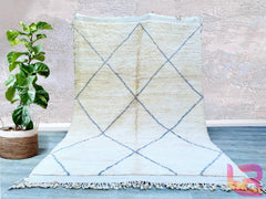 Elevate your space with this soft, plush Beni Ourain rug, a true representation of Moroccan craftsmanship. Woven by hand using premium wool, this Berber carpet features a subtle geometric pattern in neutral shades, blending seamlessly with boho, Scandinavian, or mid-century modern decor. The high-pile texture provides unmatched comfort underfoot, making it ideal for cozy living rooms or serene bedrooms. Each rug tells a story through its unique imperfections, ensuring a one-of-a-kind addition to your home. 