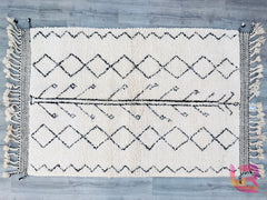 Elevate your space with a traditional Beni Ourain Moroccan carpet, a handwoven masterpiece that doubles as functional floor art. Made from premium undyed wool, this Berber rug boasts a plush, high-pile texture and a distinctive diamond or linear pattern in soft ivory and charcoal. Its versatile neutral palette complements minimalist, eclectic, or farmhouse décor. Perfect for layering over hardwood floors or low-pile rugs, this Moroccan wool carpet adds coziness and sophistication to any room. Handcrafted wi