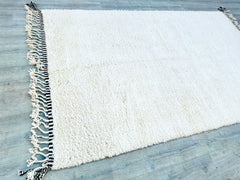 Discover the artisanal beauty of this authentic Beni Ourain Moroccan rug, a hand-knotted wool masterpiece in a spacious 8.5 FT x 11.7 FT (8x12) size. Known for their signature ivory background and charcoal tribal motifs, these rugs are handwoven by Berber women using centuries-old techniques. The ultra-soft, high-pile texture creates a luxurious feel, perfect for barefoot comfort. Whether styled in a modern loft, farmhouse, or global-inspired home, this rug adds organic warmth and texture. Each piece is uni
