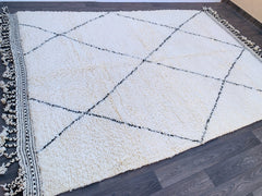Enhance your home with a vintage Beni Ourain Moroccan rug, a handwoven masterpiece from the Atlas Mountains. Made from natural, undyed wool, this soft, durable Berber rug features geometric tribal designs in neutral tones, fitting Scandinavian, eclectic, or mid-century decor. Whether you need a large area rug or a custom-sized floor covering, this eco-friendly, non-toxic carpet is a statement piece for luxury interiors. Free shipping available on select stores. A unique, artisanal treasure that ages beautif