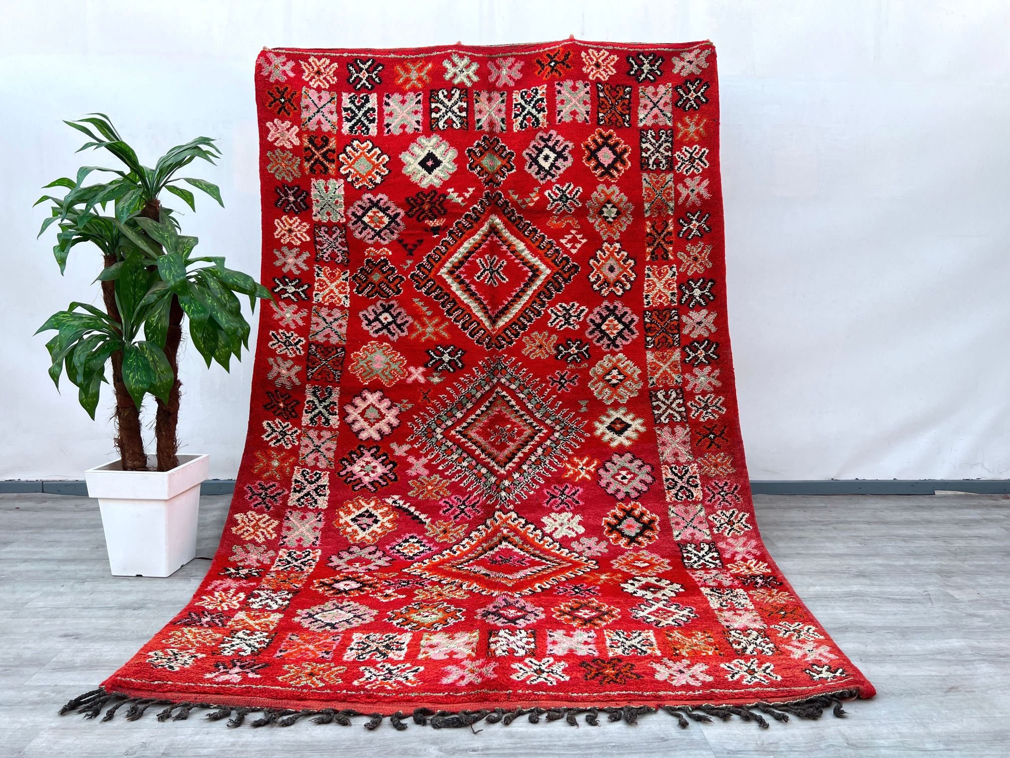 Crafted with care, this 6x10 ft vintage Moroccan rug showcases the finest hand-knotted wool, embodying centuries-old weaving traditions. The Berber tribal motifs, influenced by Boujaad and Azilal heritage, tell a story of nomadic artistry. The natural wool fibers provide softness underfoot while ensuring longevity. Ideal for bohemian, rustic, or modern interiors, this rug blends seamlessly into any décor. Its faded hues and aged texture enhance its antique appeal, making it a sought-after collector’s item. 