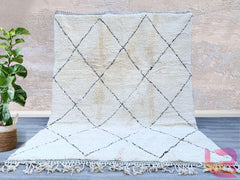 Enhance your space with a vintage Moroccan wool rug, a stunning handmade Berber carpet featuring organic patterns and a luxurious shag pile. Woven by traditional artisans, this bohemian area rug blends natural wool’s softness with bold black and white tribal motifs. Ideal for boho-chic, Scandinavian, or eclectic décor, it adds texture and warmth to any room. The durable, hand-knotted construction ensures longevity, while its neutral tones effortlessly complement any color scheme. Whether used as a statement